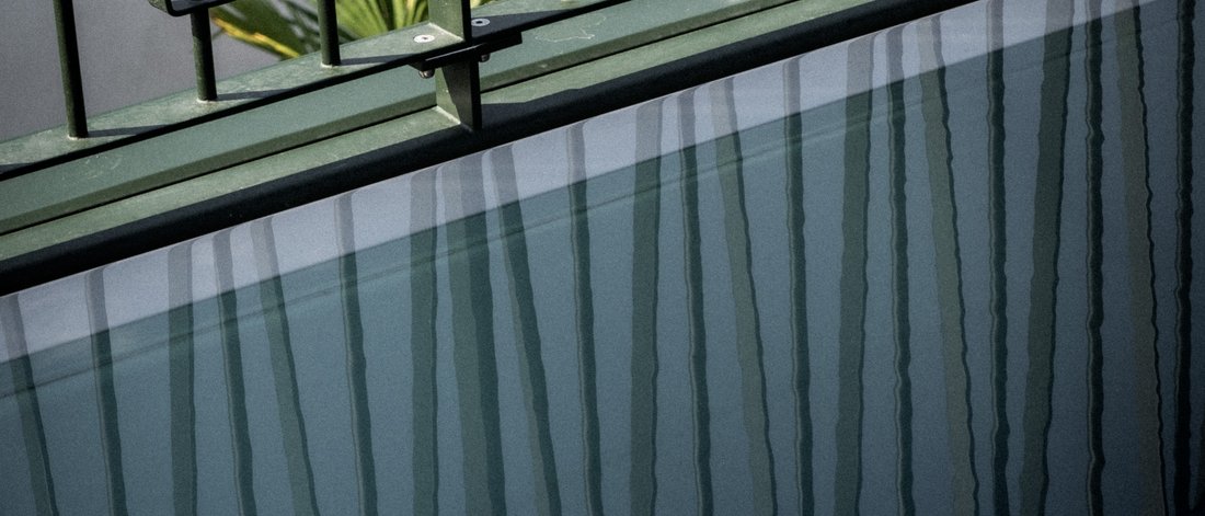 Reflection of metal railing on the water surface of a small pool