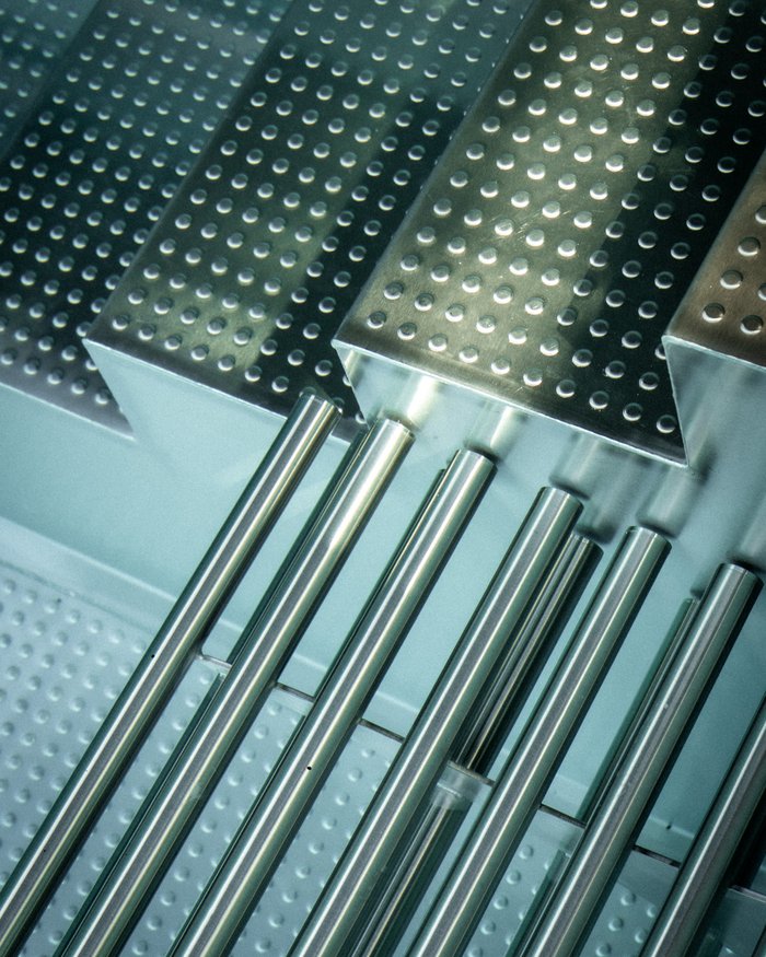 Close-up of shiny perforated metal tubes and plates