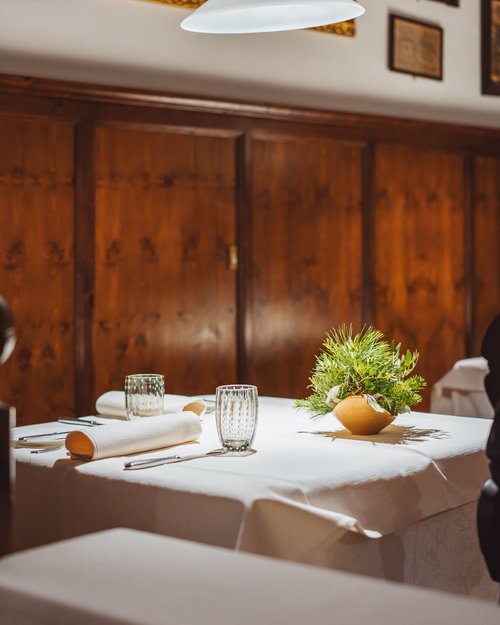 Ein gedeckter Tisch mit weißen Tüchern und einer grünen Tischdekoration