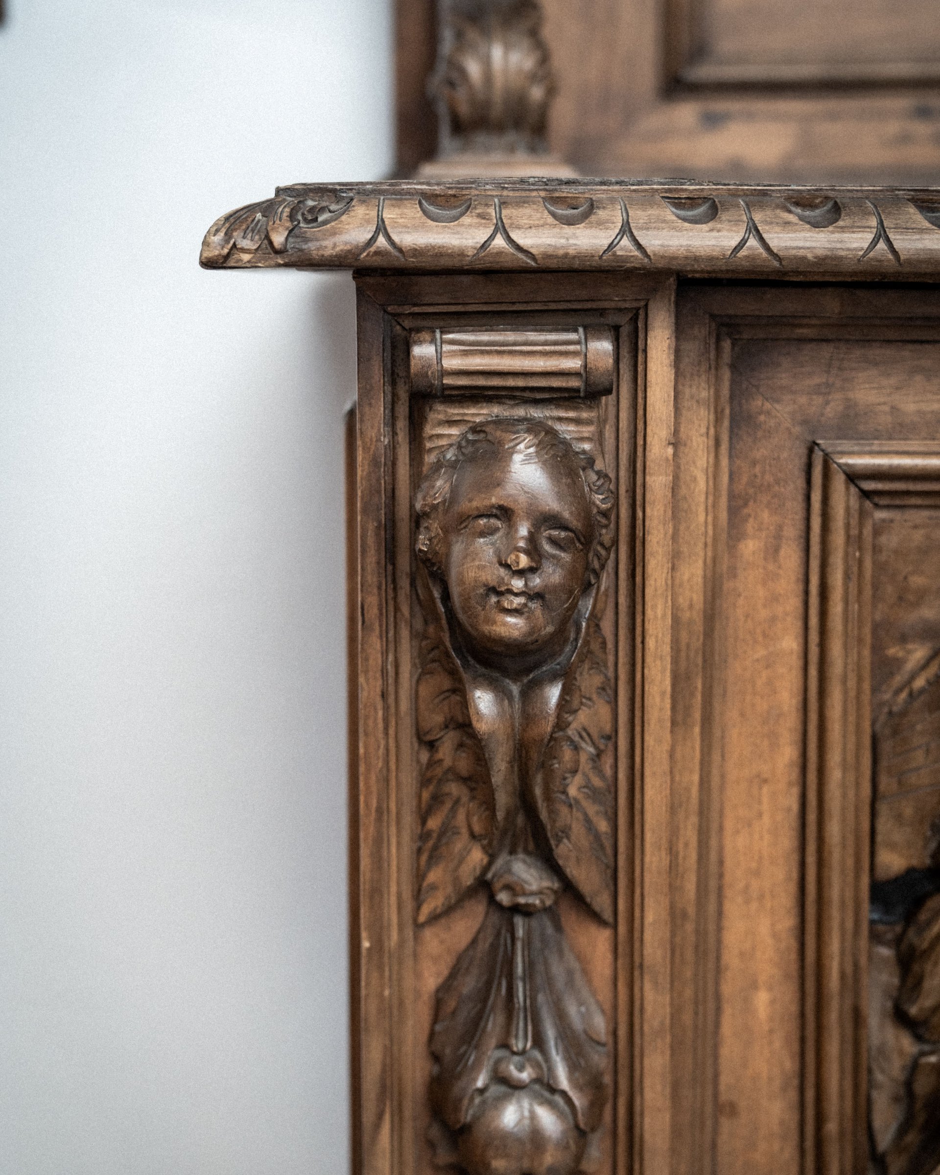 Close-up of wooden carving with human face on a piece of furniture