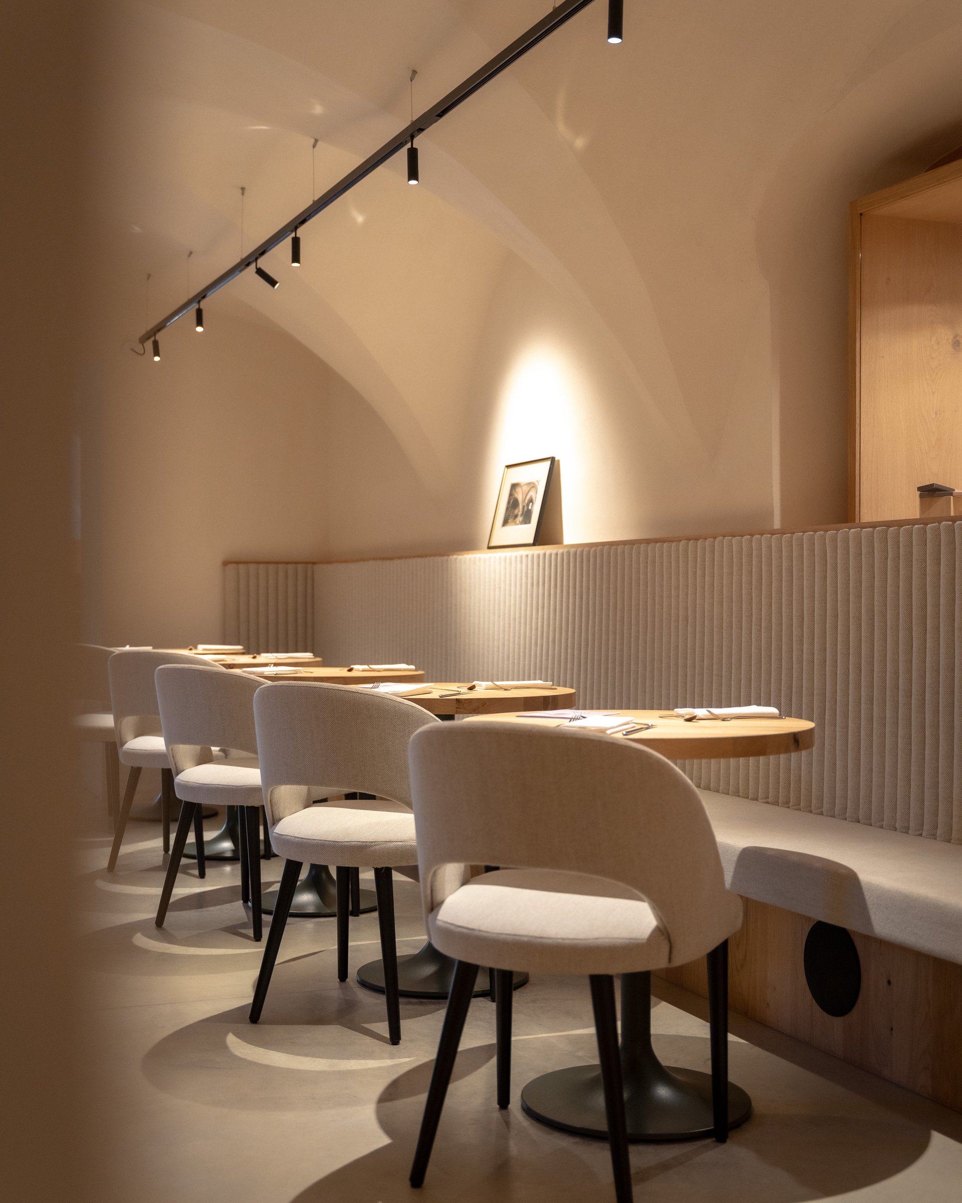 Innenraum eines modernen, minimalistisch eingerichteten Restaurants mit Stühlen und Tischen