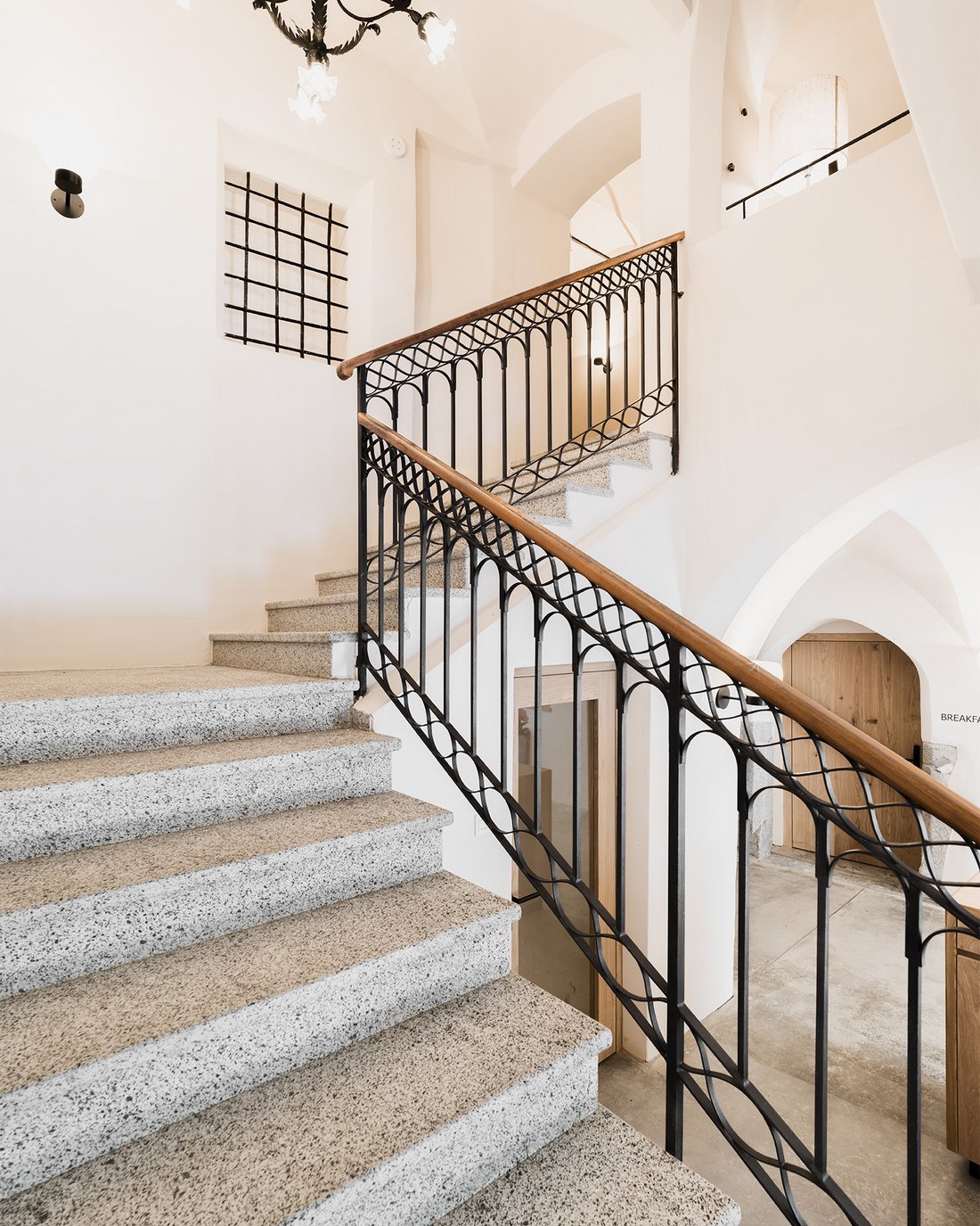 Helle Treppe mit Metallgeländer und Holzhandlauf in einem modernen Gebäude