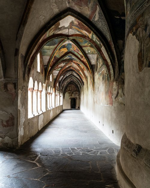 Gothic cloister with painted vaulted ceilings and arched windows