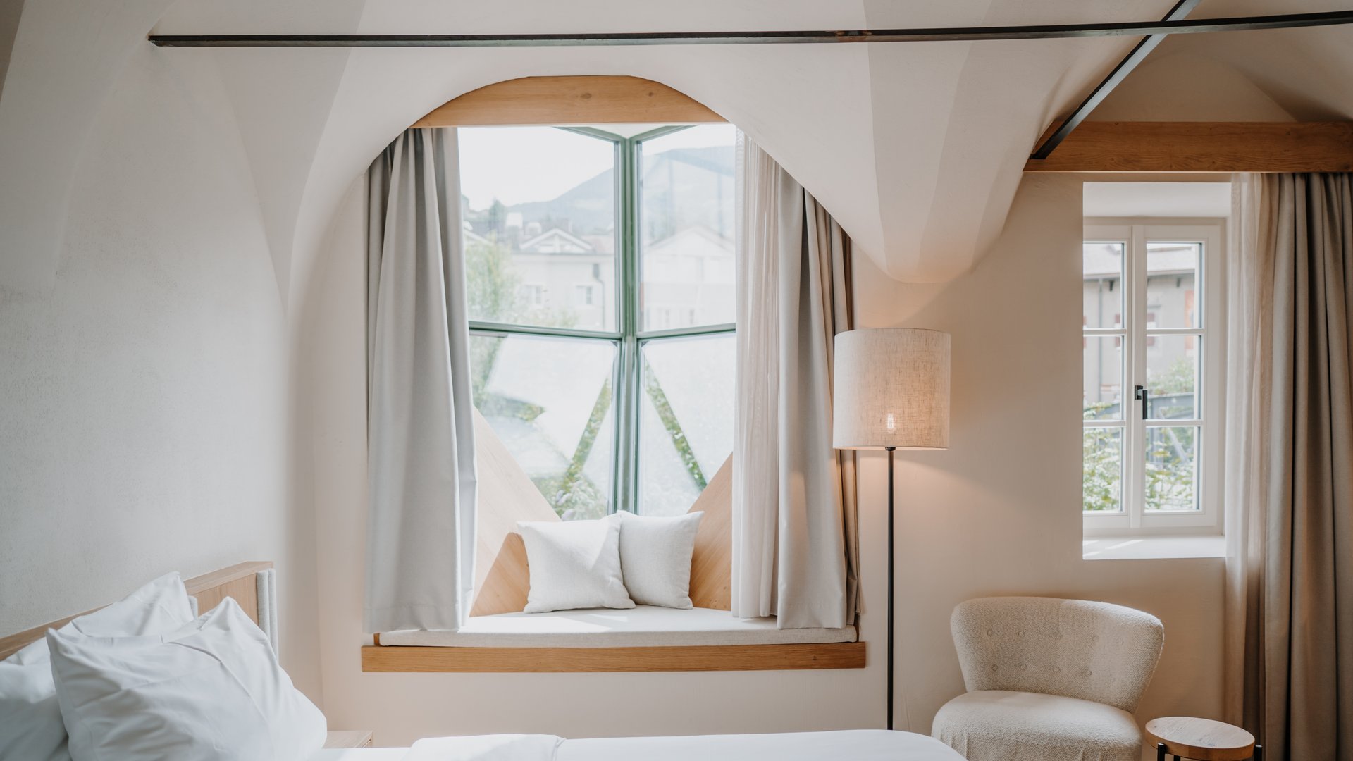 Bright bedroom with padded window seat and cozy armchair
