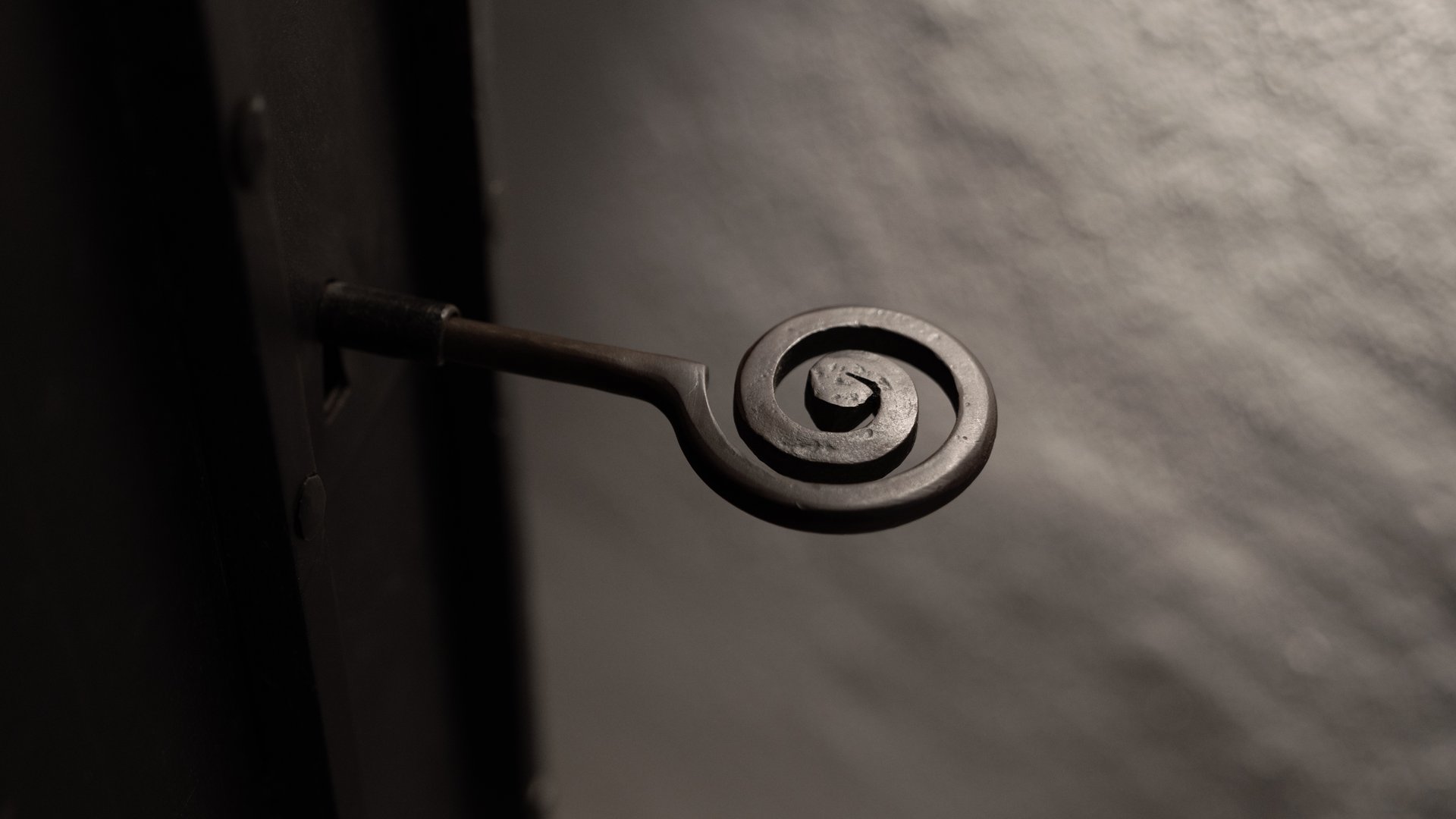 Metalltürgriff mit Spiralgriff in dunkler Umgebung