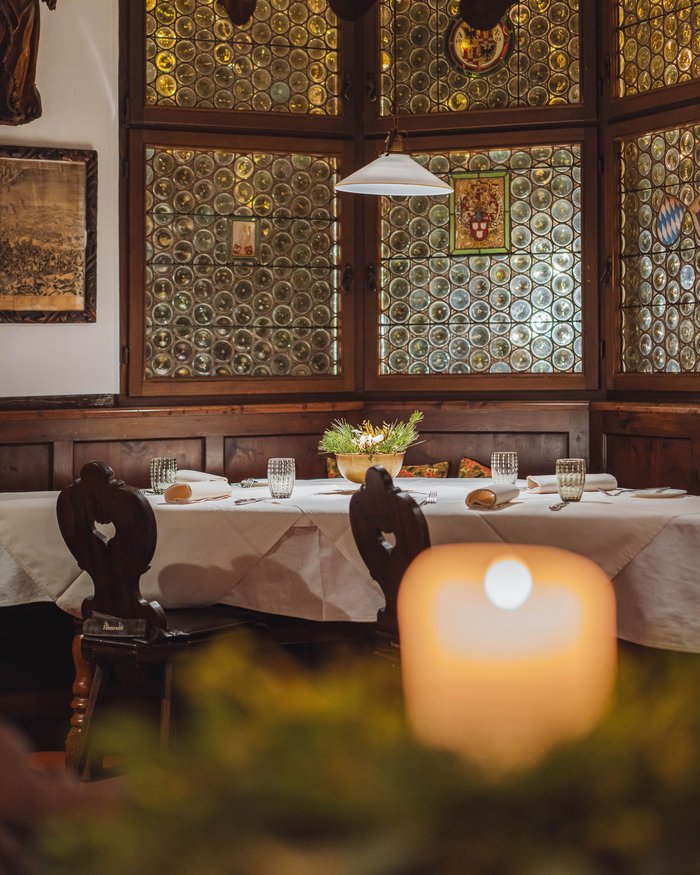 Gemütlicher Essbereich mit Holzstühlen und dekorativem Fenster aus Glasbläser-Kugeln.
