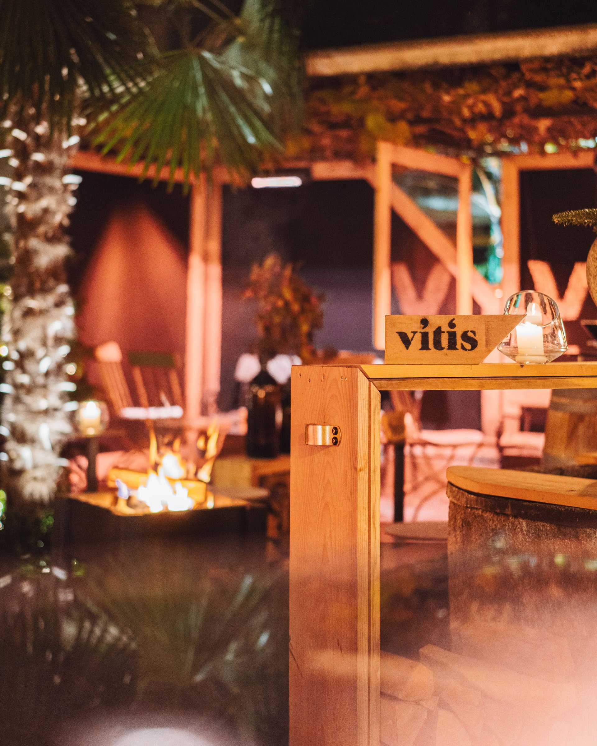 Cozy terrace with fire pit, wooden furniture, and candle lighting