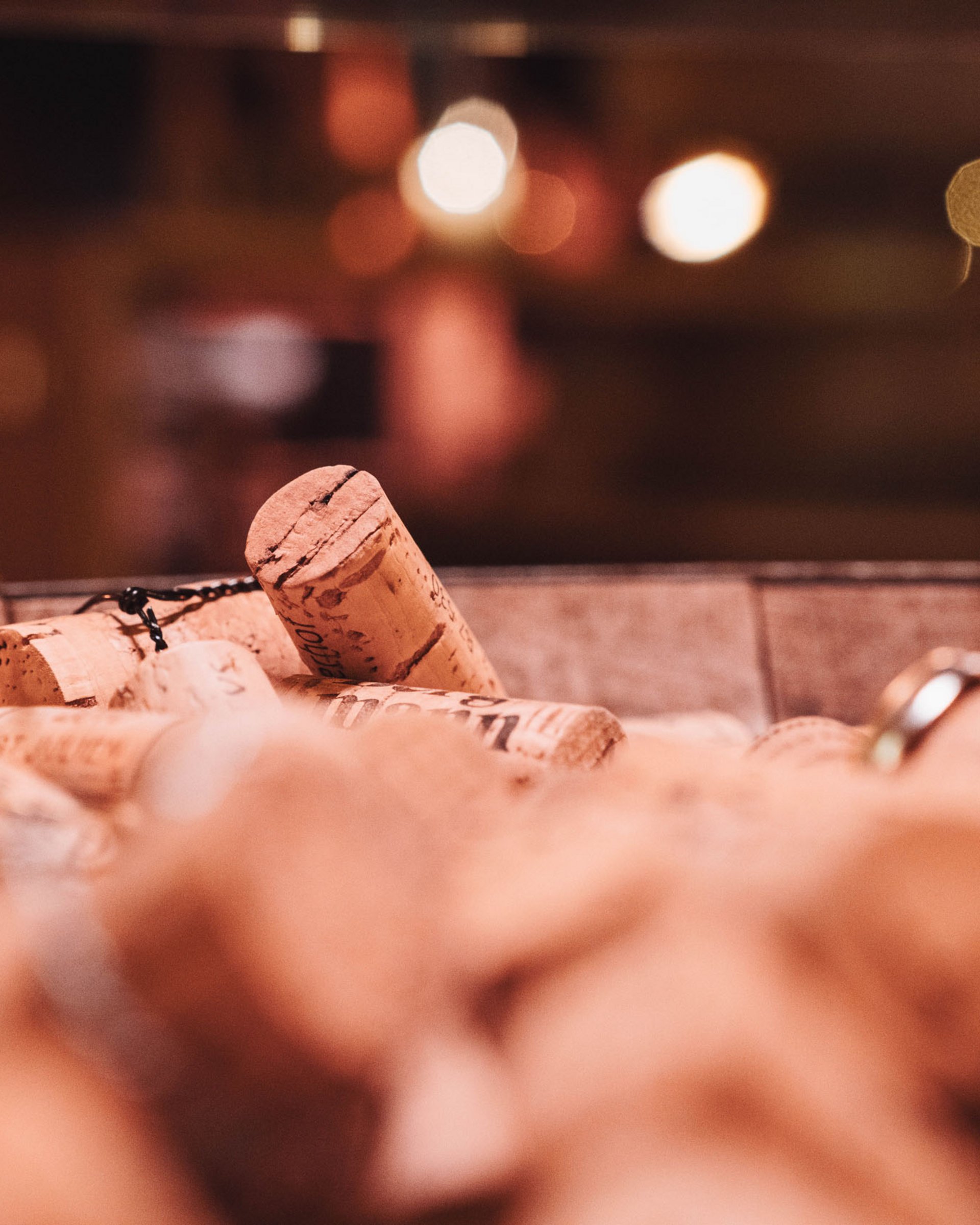 Close-up of many wine bottle corks in a container with blurred background