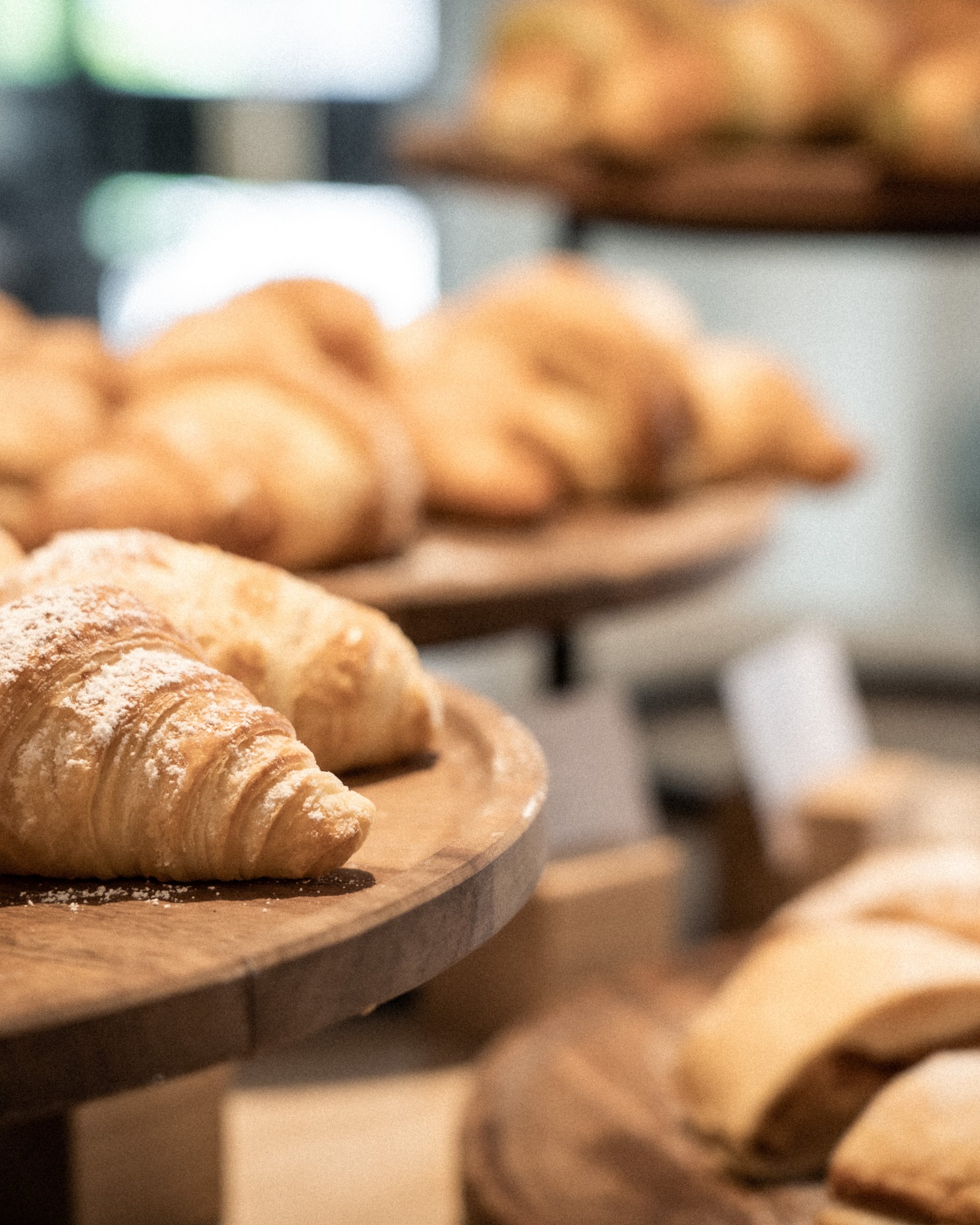 Frisch gebackene Croissants auf Holztabletts in einer Bäckerei