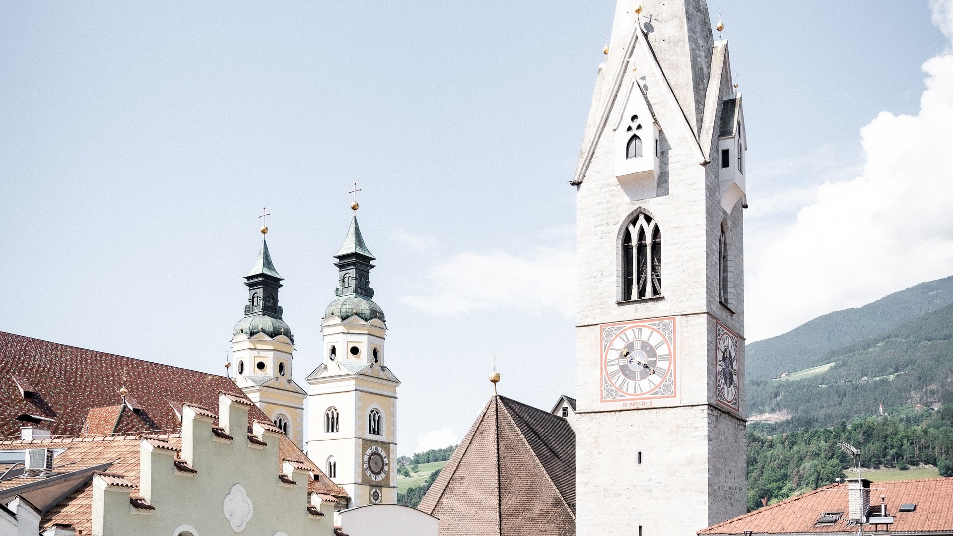 View of church towers and rooftops in a city under clear sky