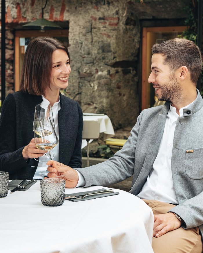 Couple clinking wine glasses outdoors at a restaurant
