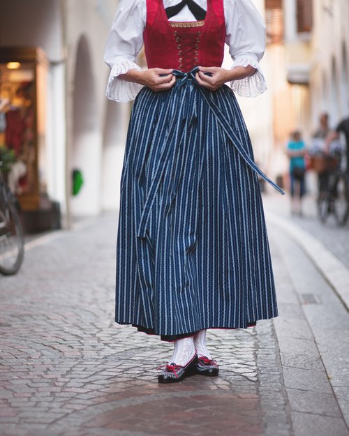 Frau in traditioneller Tracht mit rotem Mieder und blau gestreiftem Rock