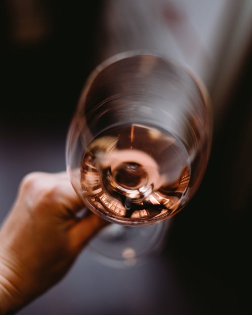 Hand holding a glass of rosé wine