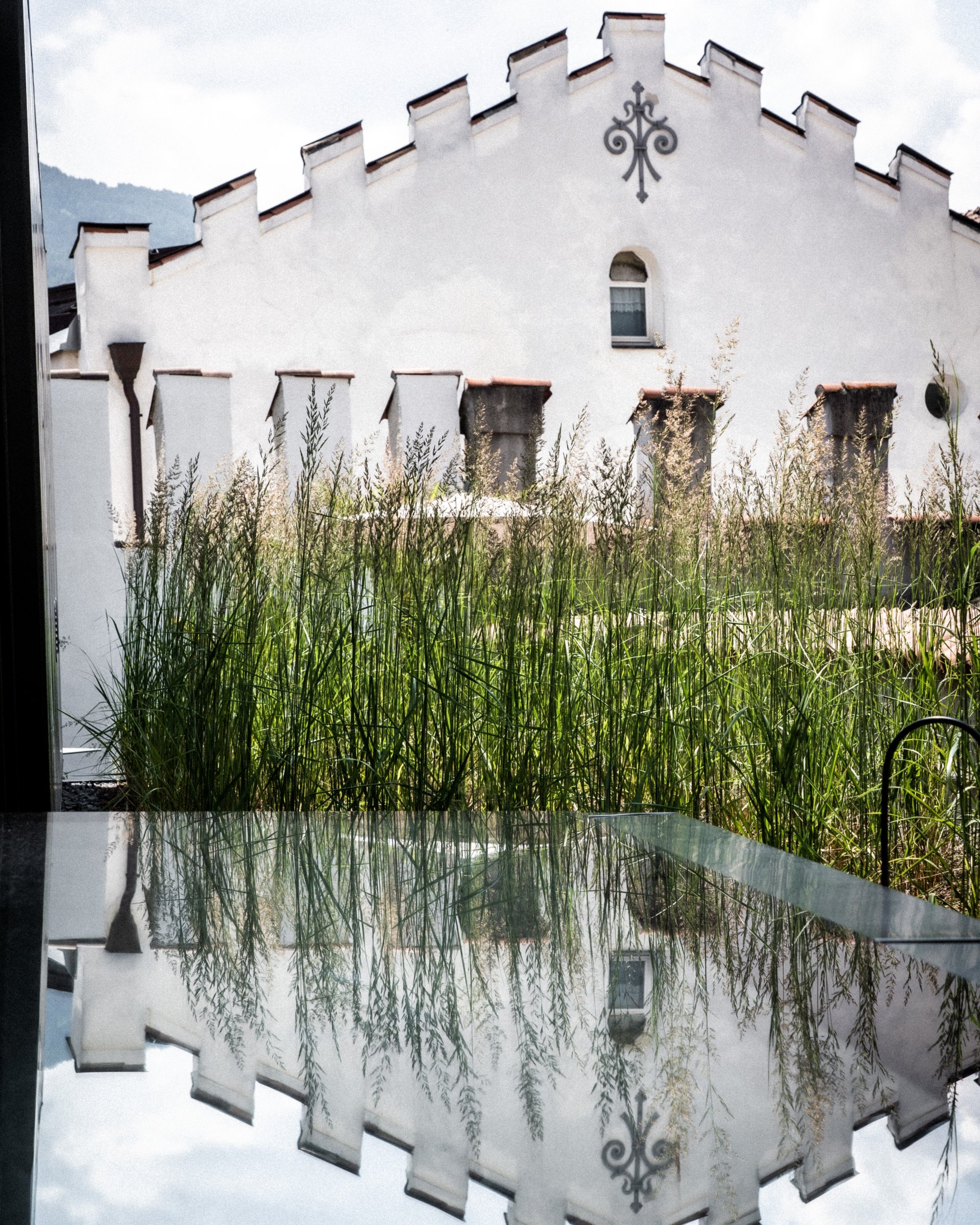 Weißes historisches Gebäude mit Zinnen und Gräsern im Vordergrund