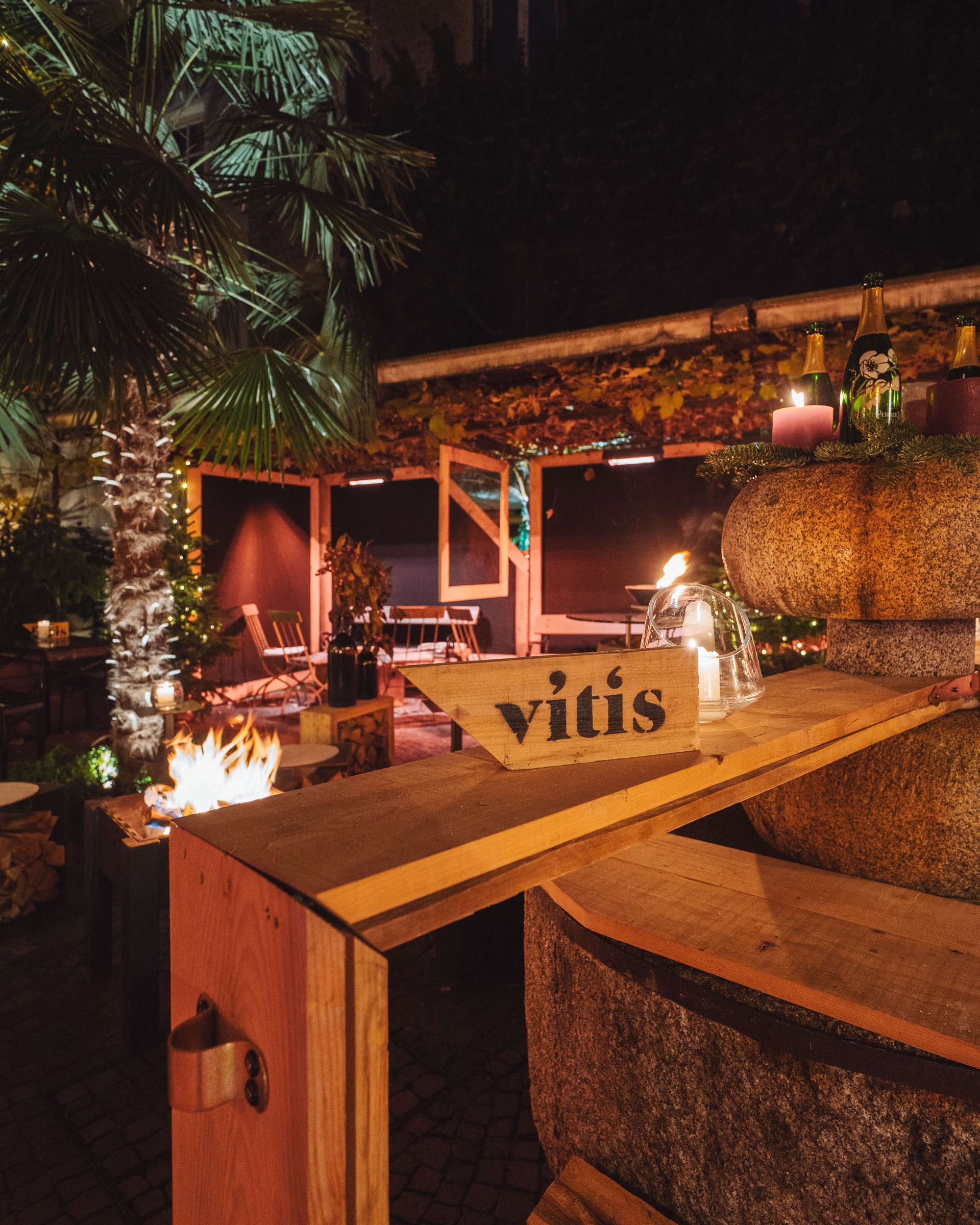 Cozy outdoor area with fire pit and Vitis sign at night