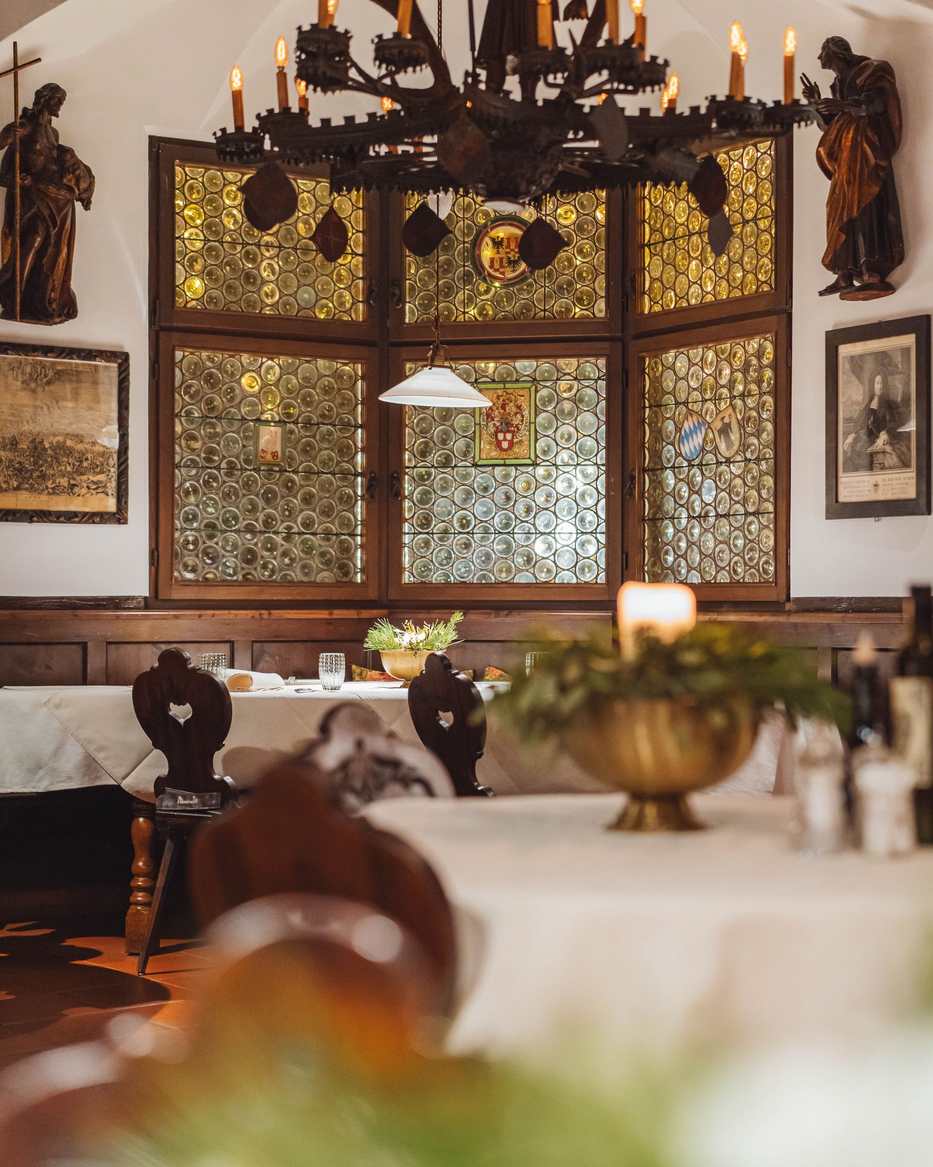 Cozy restaurant with ornate chandelier and decorated windows