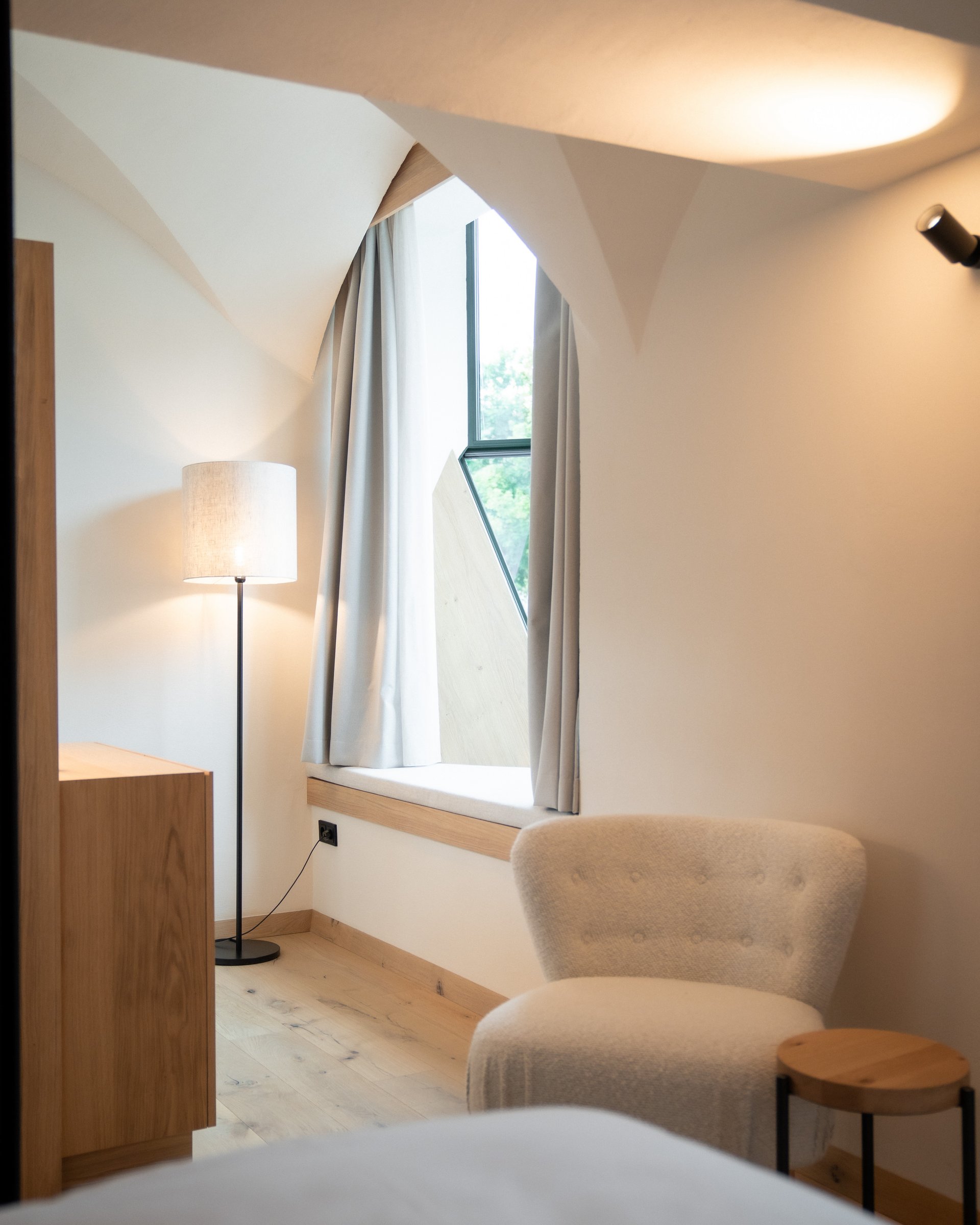 Ein gemütlicher Sitzbereich mit Stuhl, Fensterbank und Stehlampe in einem Zimmer