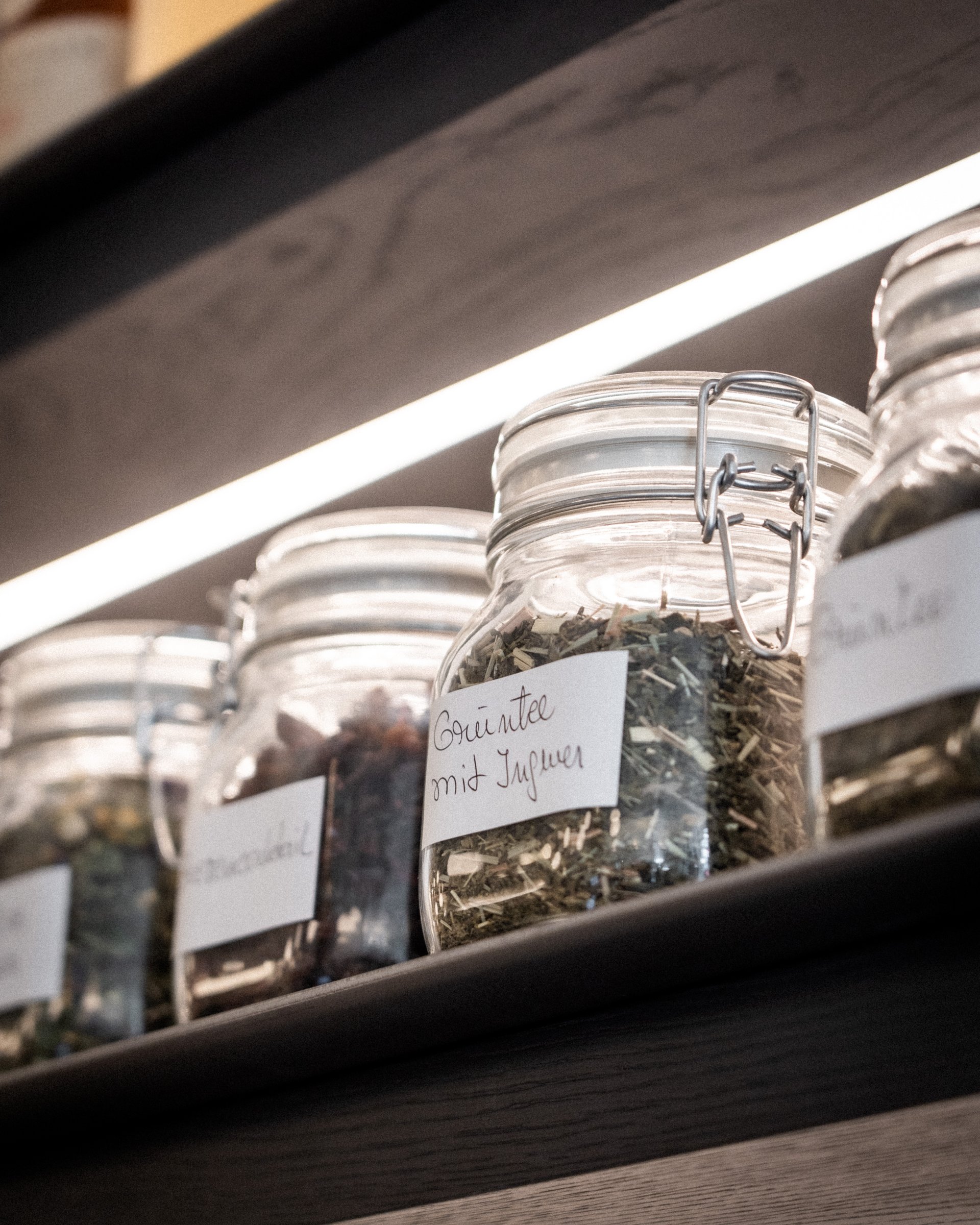 Gläser mit getrockneten Kräutern und Gewürzen auf einem Regal