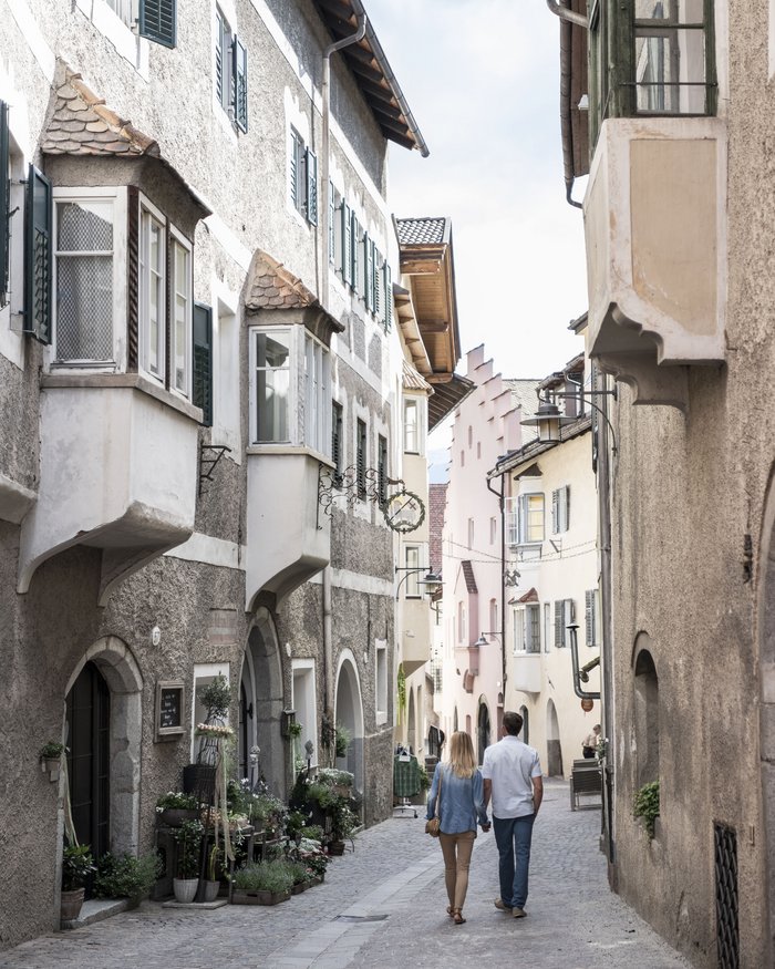 Couple walking down a cobblestone street in a historic old town