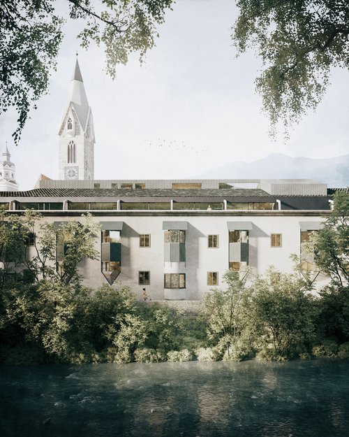Altes Gebäude mit spitzem Kirchturm und Fluss im Vordergrund
