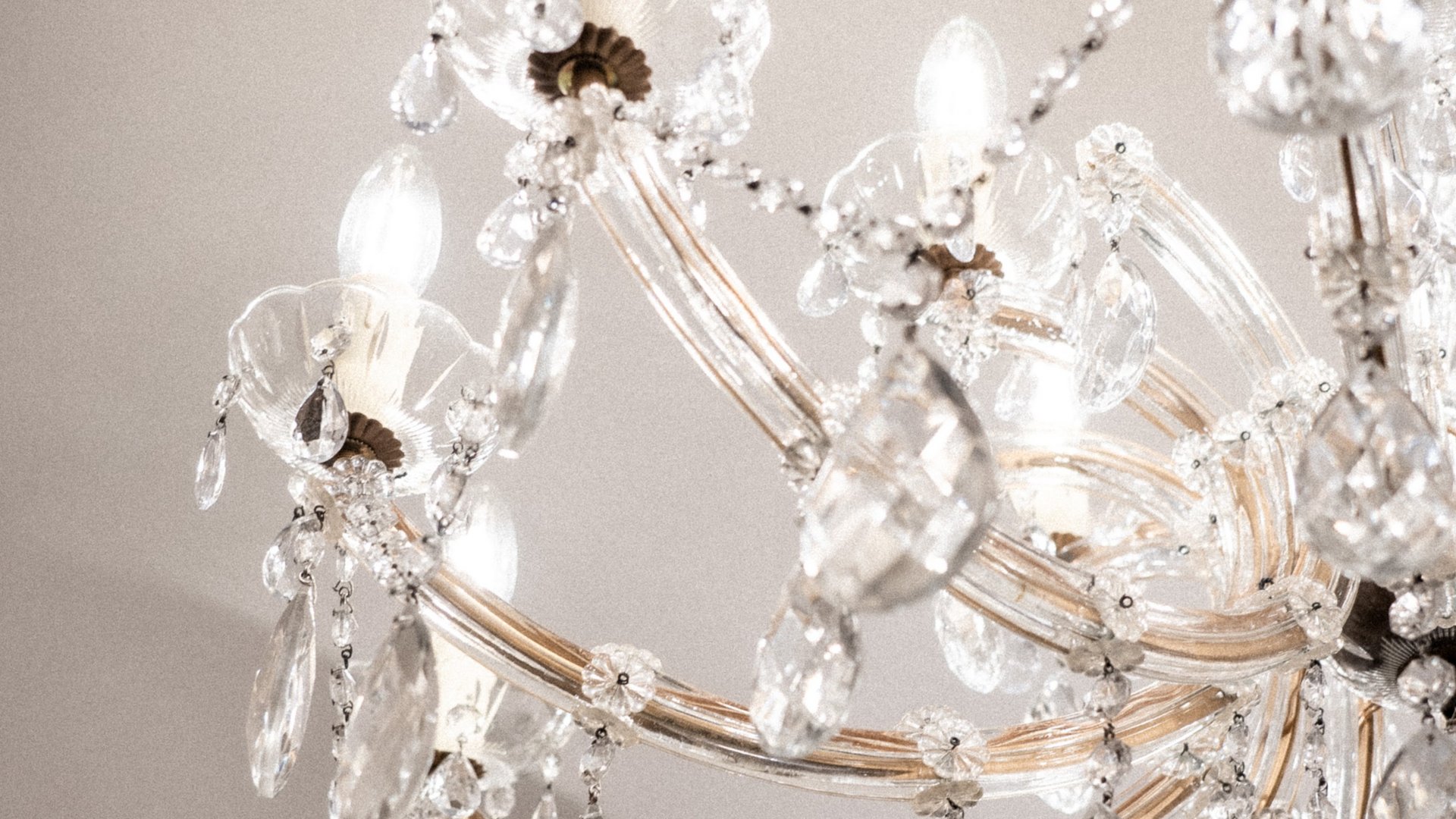 Close-up of a lit crystal chandelier hanging from the ceiling