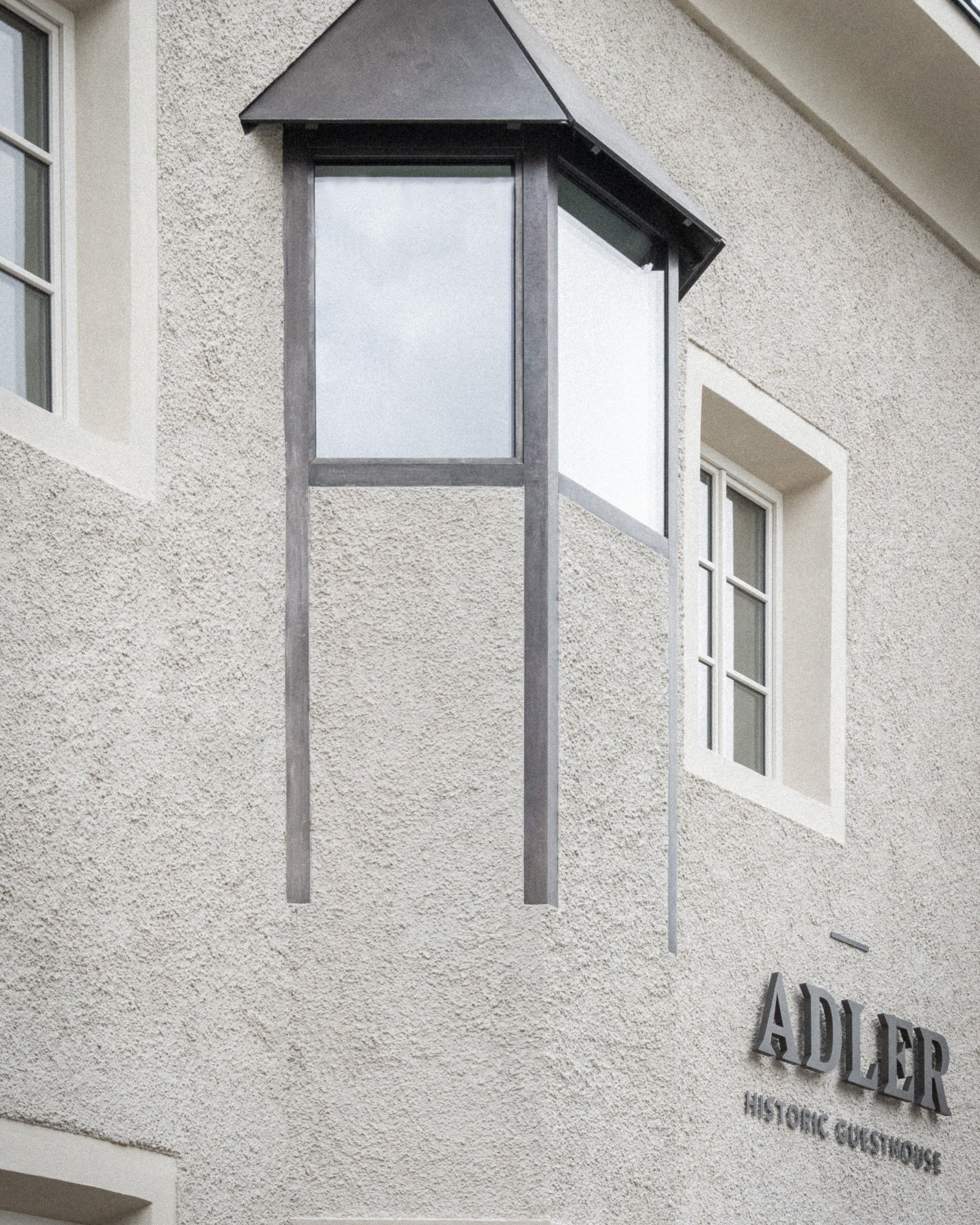 Fassade eines historischen Gästehauses mit Erkerfenster und Adler-Schriftzug